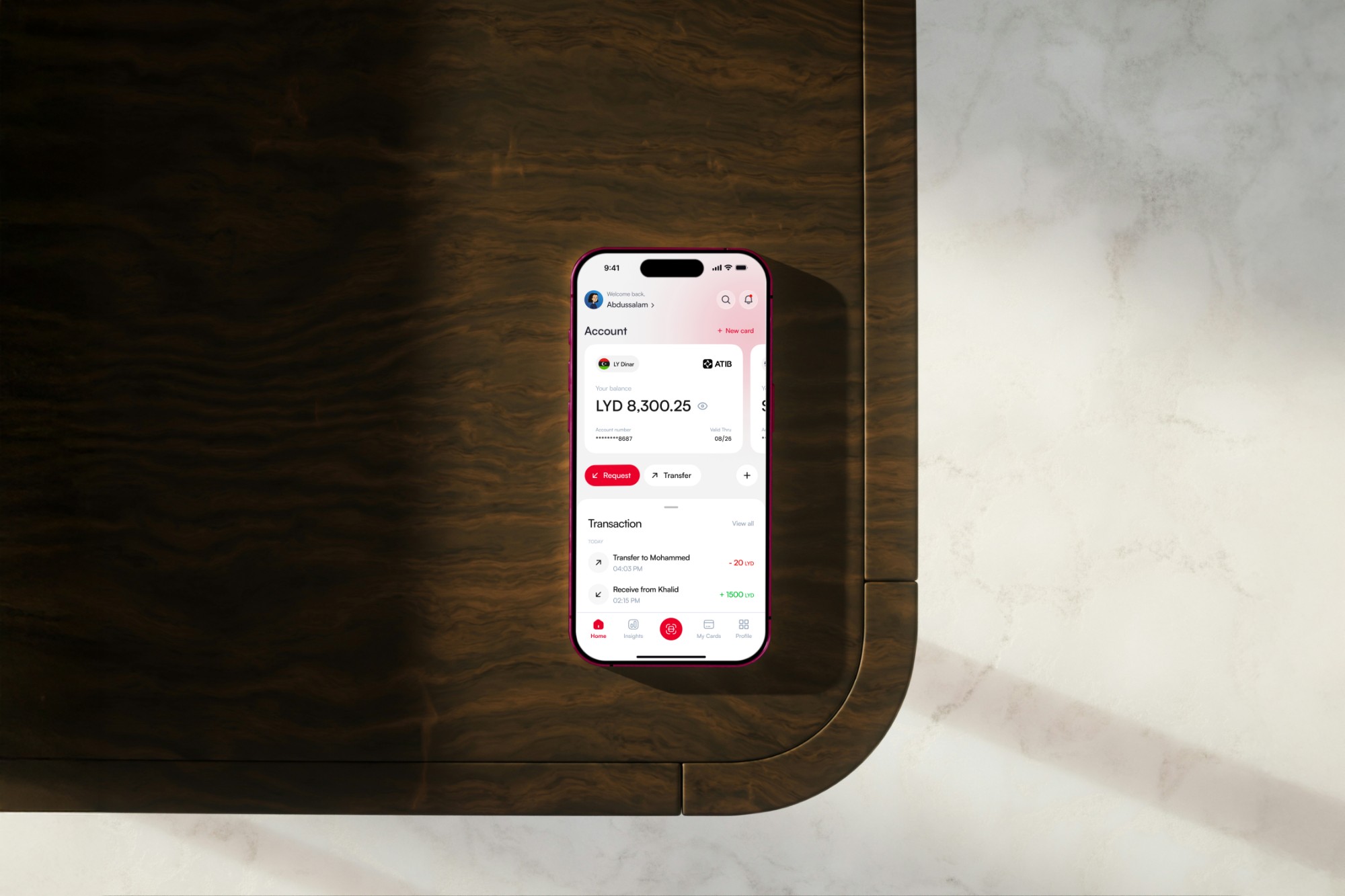 An iPhone on a wooden table showing the new ATIB home screen