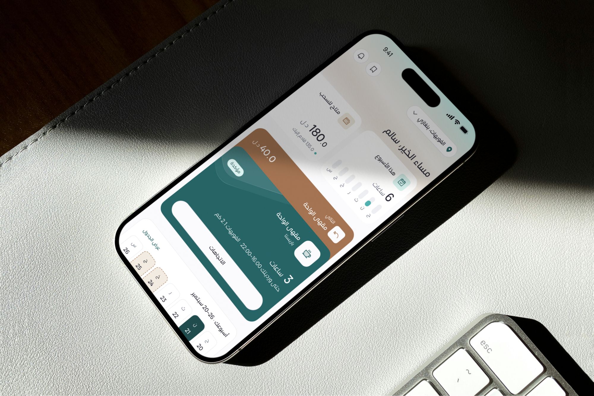An iPhone on a desk showing Tamm's home screen in Arabic